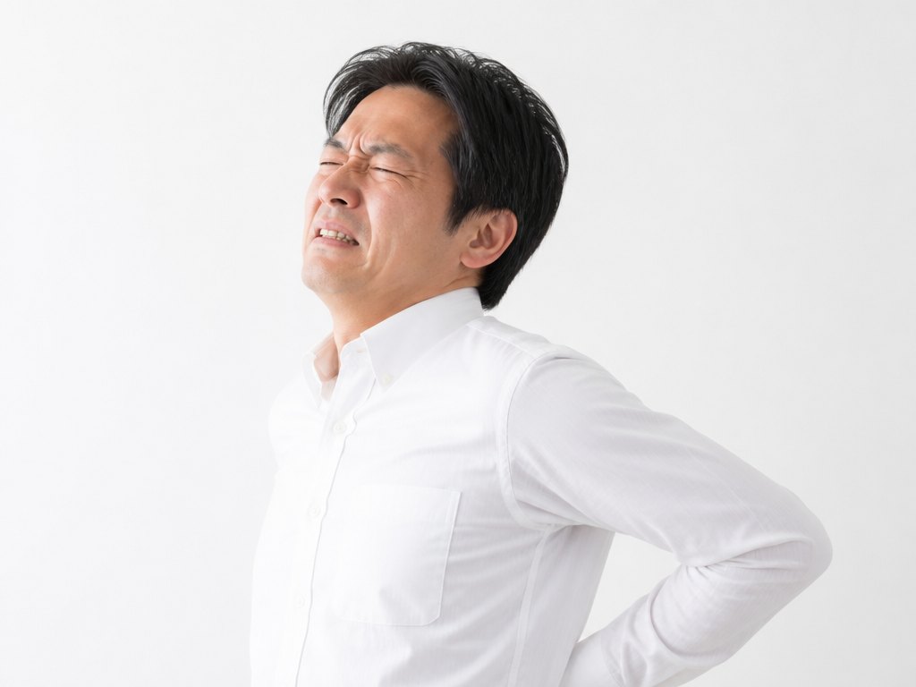 腰に手を当てる男性（腰痛・ぎっくり腰）