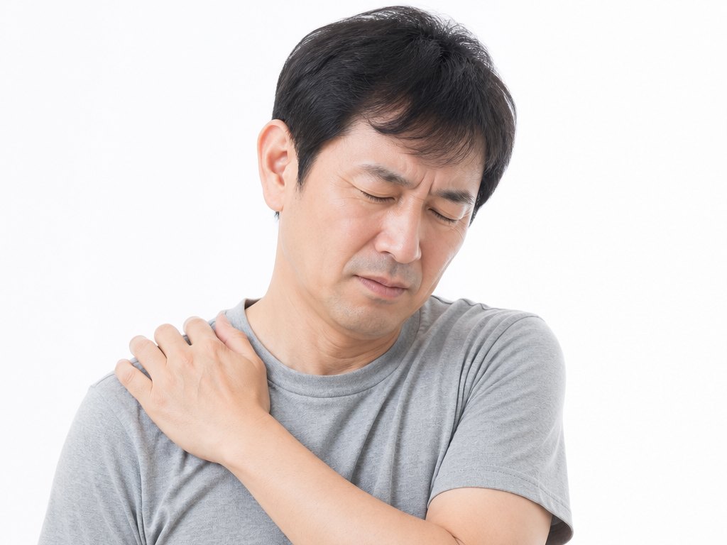 肩を押さえる男性（五十肩・肩の痛み）