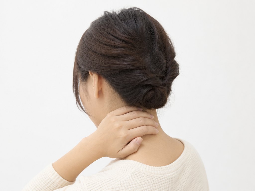 首の後ろを押さえる女性（ヘルニア・慢性痛）